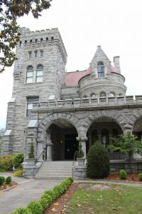A photograph of the fortress-like exterior of haunted Rhodes Hall. The estate is said to be haunted by the ghosts of its former owners, Amos and Amanda Rhodes.